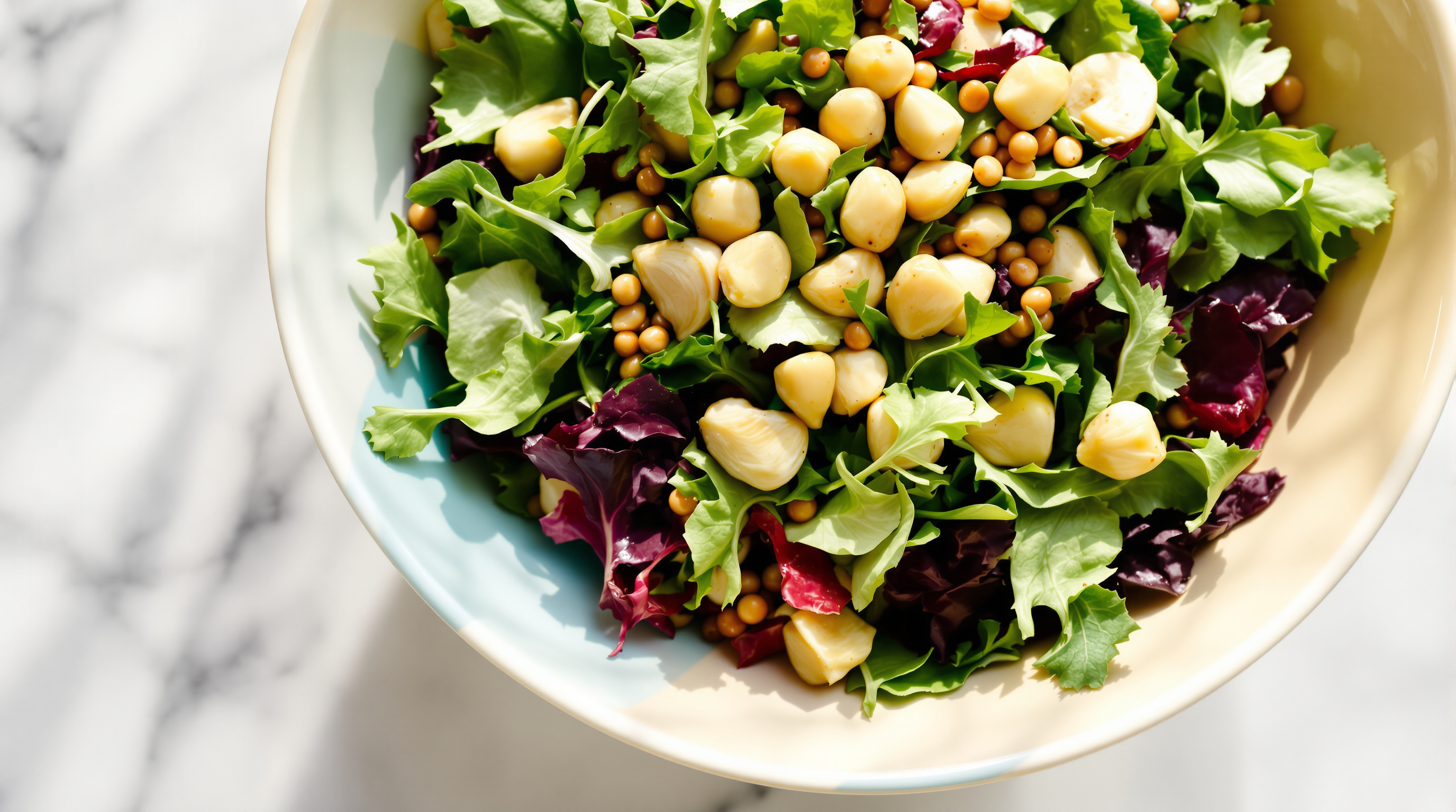 Bunter Salat mit Radicchio, Rucola und Artischockenherzen auf weißer Marmorplatte